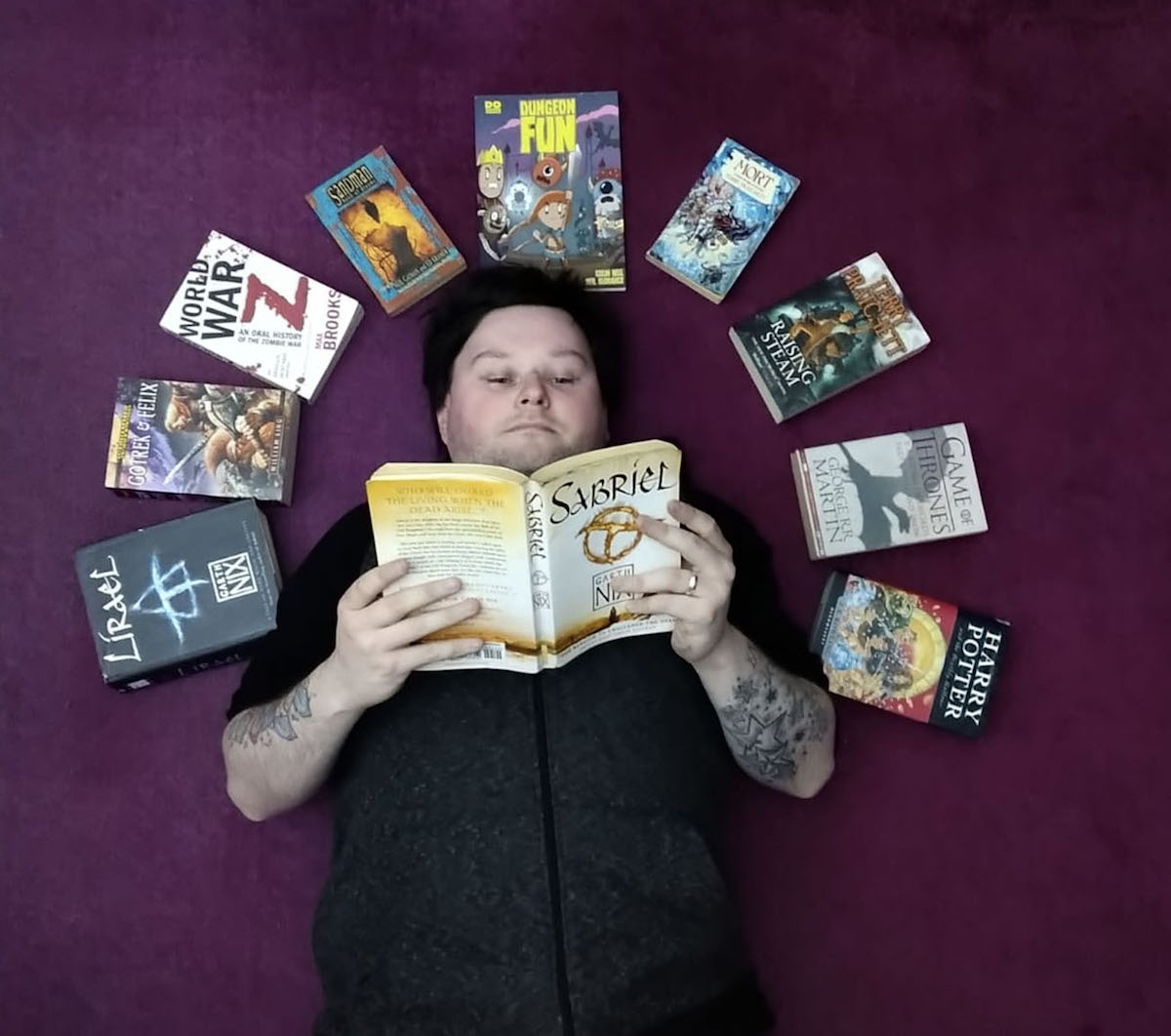 When we first saw this photo we thought he was hanging upside down!  The multi-talented Raymond from our team has made this beautiful book halo but has settled on the brilliant  #fantasy novel 'Sabriel' to read by  @garthnix  #ReadingHour  #WorldBookNight