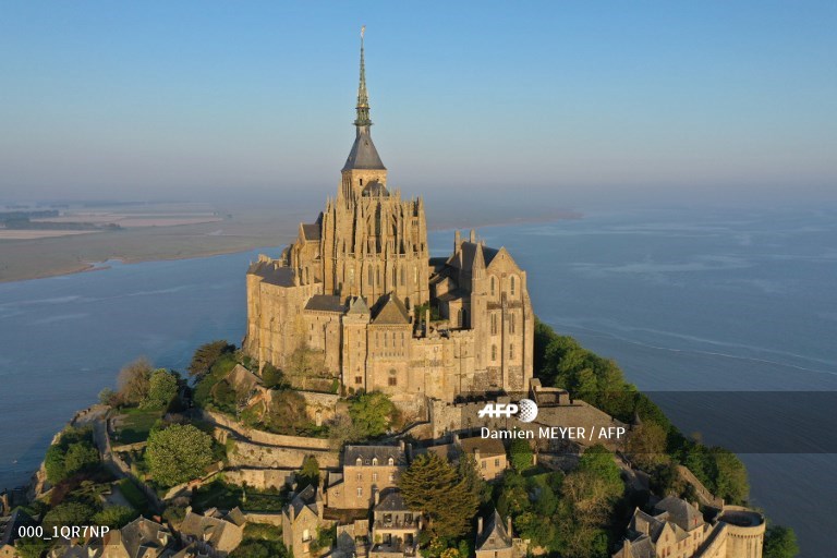 AFPphoto's tweet photo. #France 
Mont-Saint-Michel from above at #sunrise
https://t.co/tQpjDFUhZ2
📸 @DamienMeyerAfp https://t.co/Ahy6Hws54m