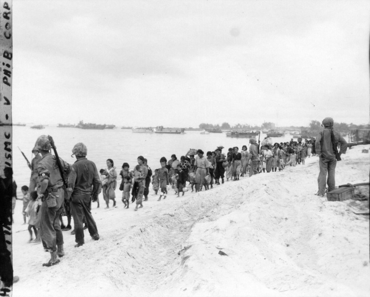  3: Des femmes et des enfants japonais évacuent sous les yeux des soldats américains à Saipan en juin 1944