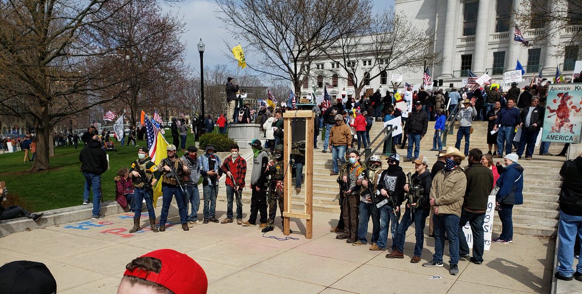 The vast majority of people at this rally were not open carrying guns. But I stumbled onto scenes like this a few times. That appears to be a guillotine they're posing next to.