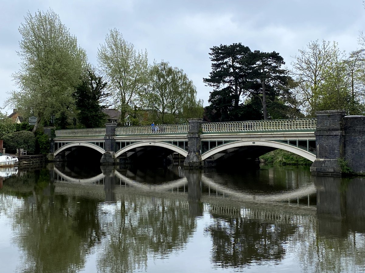 "To the W of the High Street [Bridge Road/Addlestone Road] there is first a pretty three-arched iron bridge of 1865, with stone piers and openwork spandrels in Westminster Bridge style".