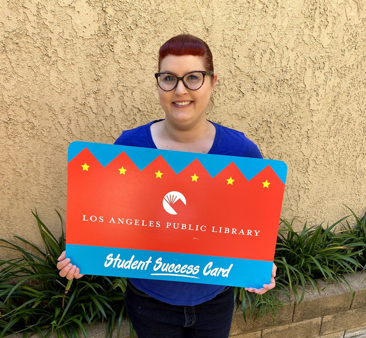 librarian holding giant student success card