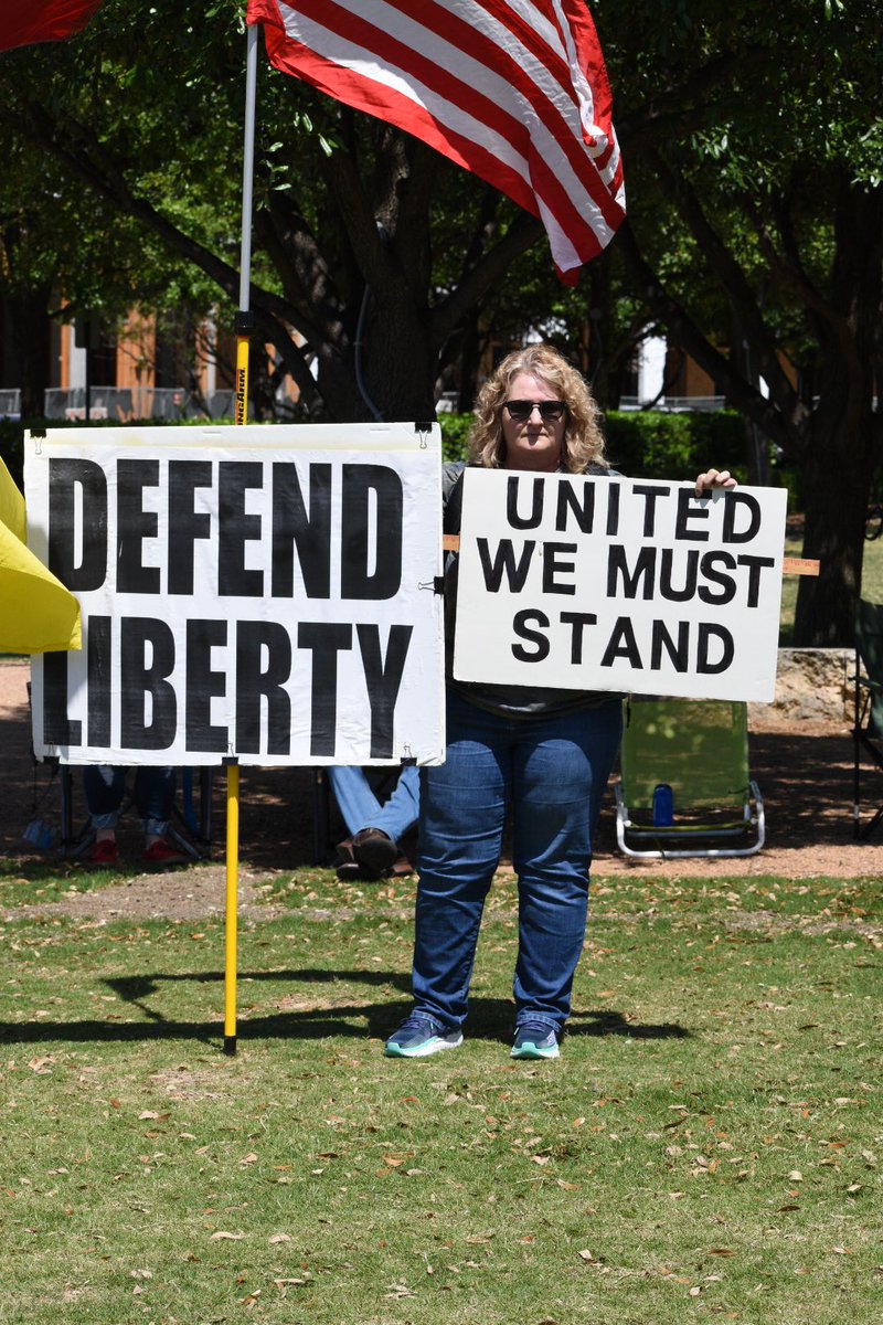 Signs include two that read, “I prefer dangerous freedom over peaceful slavery,” and “all lives matter.”  @wfaa