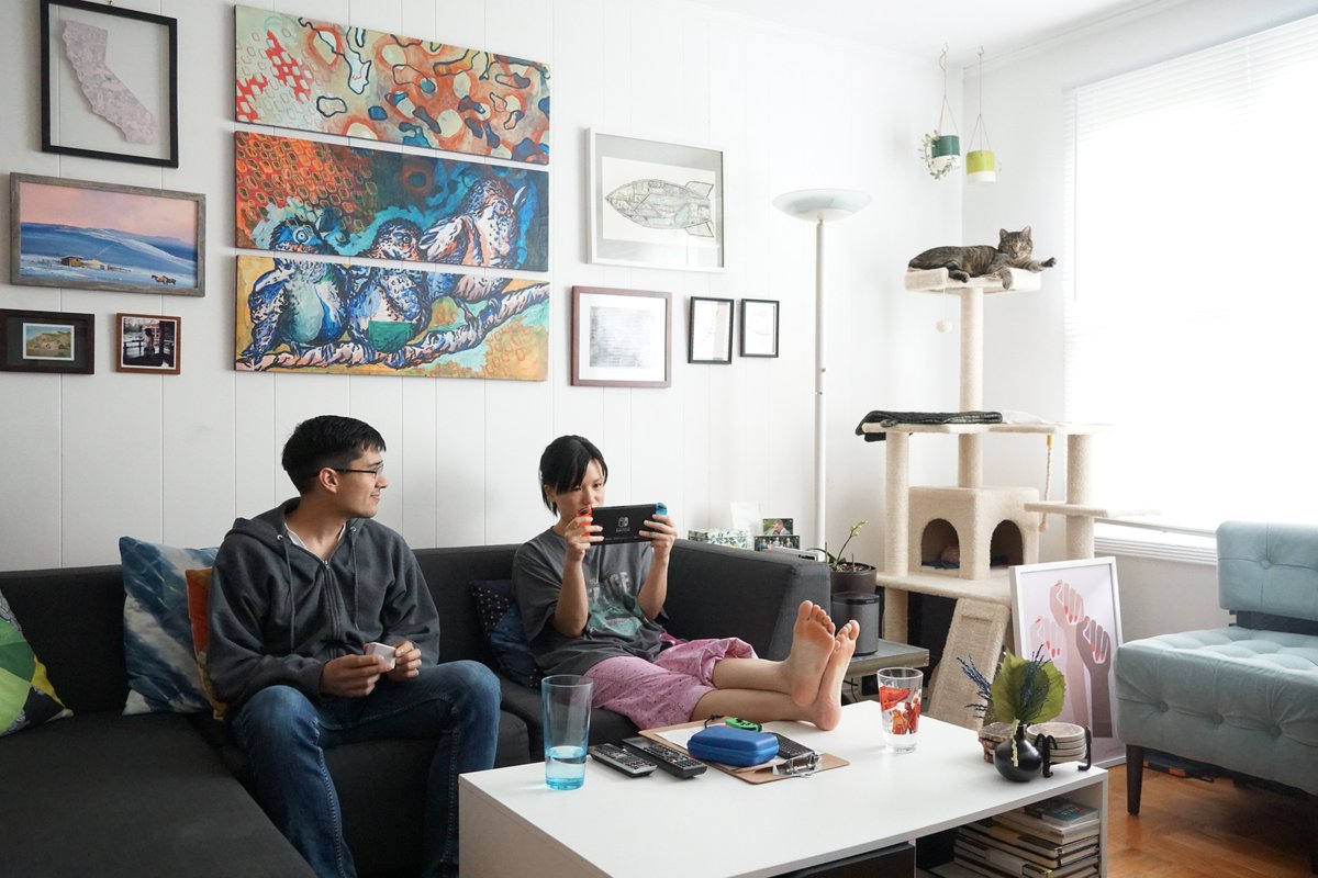 Me and Sam on the couch, my feet up on the coffee table playing Switch, Sam holding a small gray fuzzy box, and both of us wearing grungy pajamas.