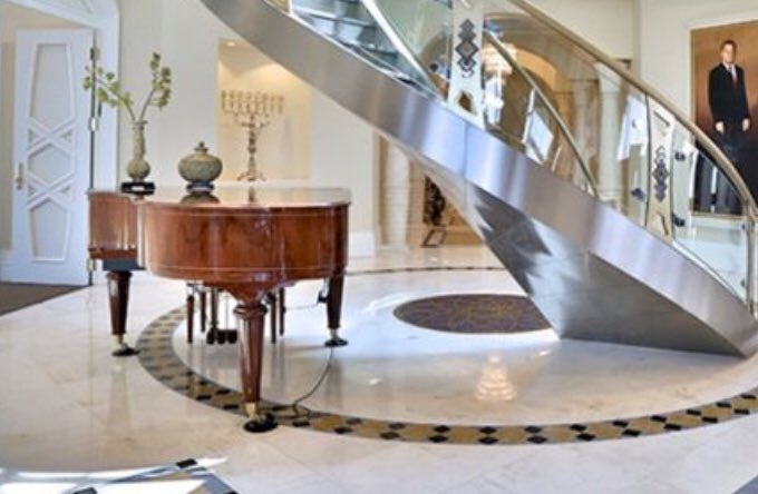 What a layout! Piano right near the grand staircase for extra awkwardness. I love how the crown moulding abruptly cuts off by the random candle hole. The arches on the right, what architecture!