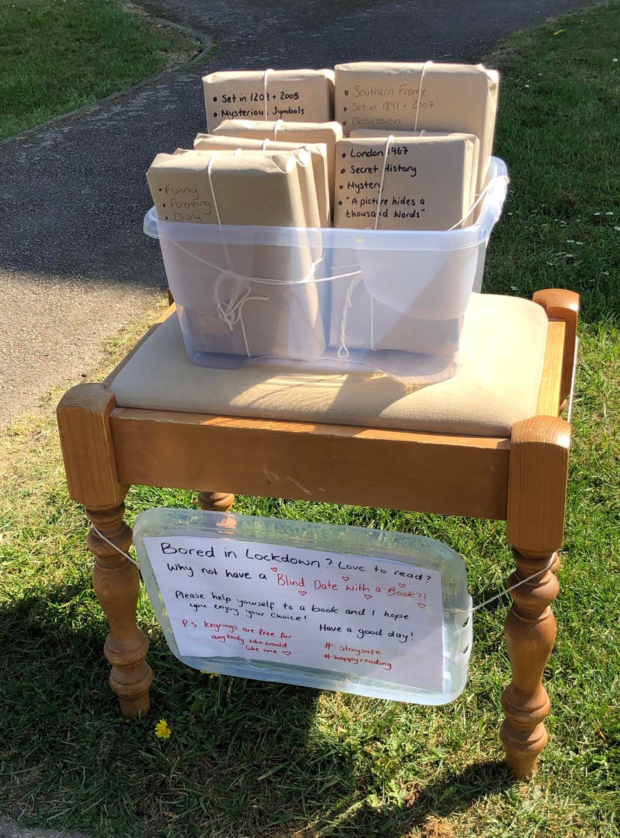 Goodable's tweet photo. In a UK neighborhood, people were leaving out toys and food on their front lawns, for passers-by to take home.

One neighbor had a better idea, so they made this.

A "blind date" with a book.

#KindnessMatters https://t.co/2sL5u8U1j2