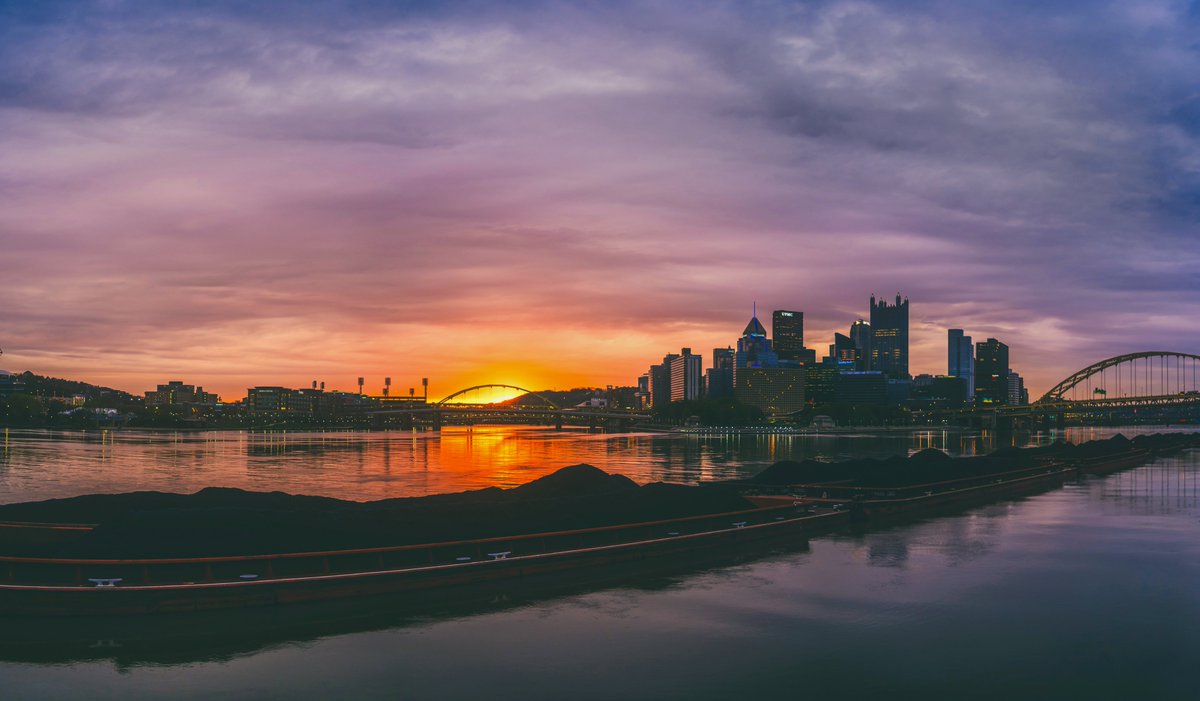 DaveDiCello's tweet image. For a few minutes this morning, there was quite the beautiful sky over #Pittsburgh. With just enough of an opening in the clouds on the horizon, the sun broke through and provided a soft, warm glow behind the city, as a handful of barges loaded with coal sat on the Ohio River.