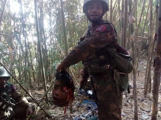 ArakanForgotten's tweet photo. AungSannSuKyi praised Military, Myanmar soldiers has killed over 500 civilians in Arakan and Chin state. Recently, a video of Myanmar soldiers torturing 5 civilians gone viral on social medias. In this photo, #Myanmar soldier posed for a pic with human head that he has beheaded. https://t.co/doHghUL6Dc