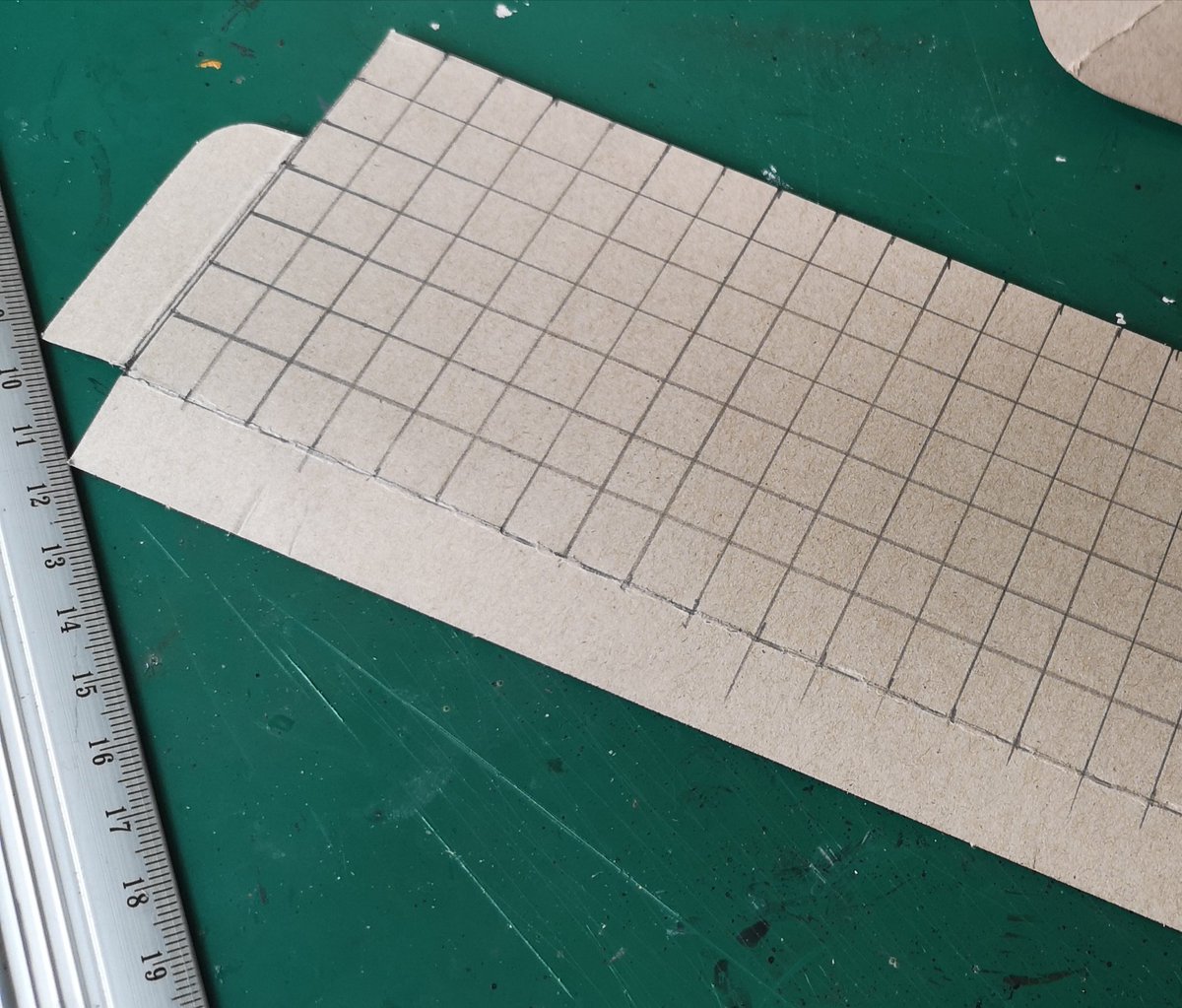 Right! Onto the roof tiles Queued all morning at the post office I made the tiles from thin card, drew a 1cm square grid & cut into strips then cut the line most of the way to make a line of tiles, then starting at the bottom I glued them to the roof. #warmongers  #ttrpg