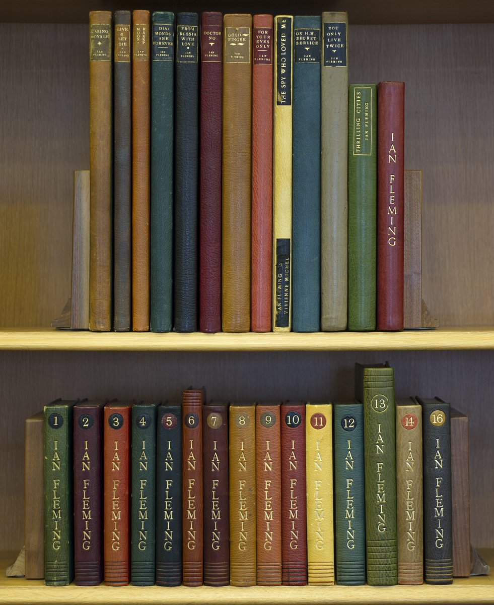 Ian Fleming was a serious book collector. Shown here are his personal custom bound copies of his James Bond books and the screenplays based on them, as well as his home library in Sevenhampton, with his famous collection of books representing milestones in science & technology.