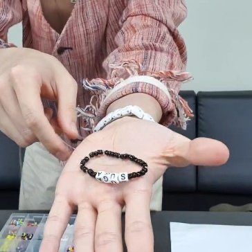 Secondly, this is Suga’s bracelet. He uses black & white color & a cat pendant that matches in Yoongi’s personality & we all know that Yoongi is our lil meow meow right? And he puts the name SUGA in that bracelet. So cute.