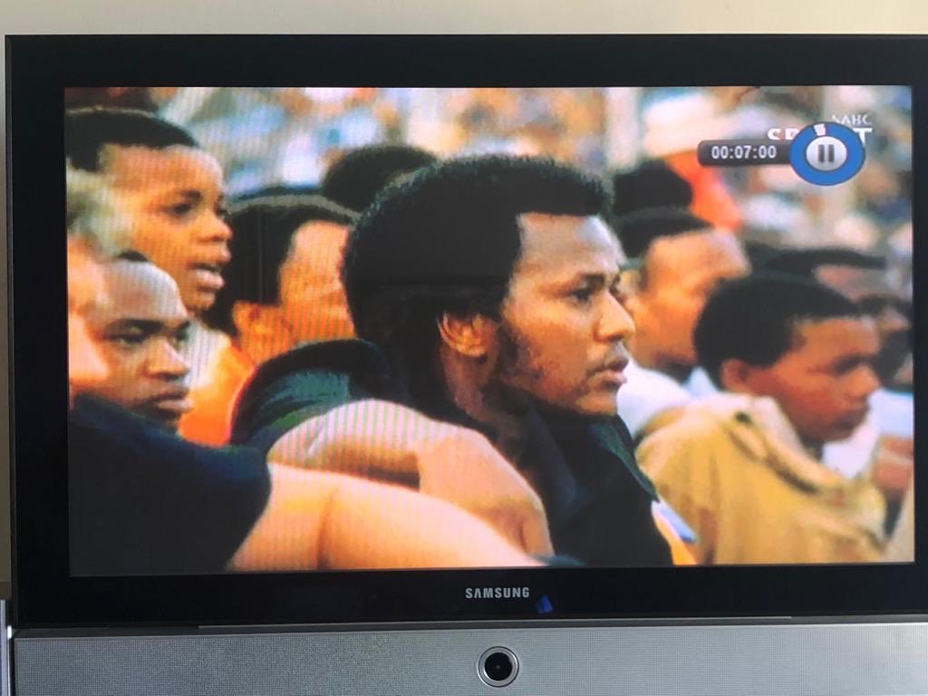 Who is that light skinned laaitie behind the <a href="/KaizerChiefs/">Kaizer Chiefs</a> chairman Kaizer Motaung in that pic? [100 marks] #FootballGoesRetro <a href="/Official_SABC1/">SABC 1</a>
