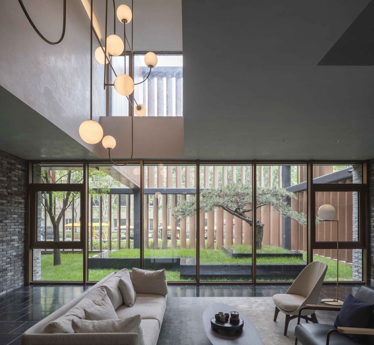 The Art gallery is equipped with a series of hanging moveable walls for a flexible display system. The sculpted ceiling above gives some visual connection to the upper level, while a large glass picture window allows the space to extend into the courtyard.