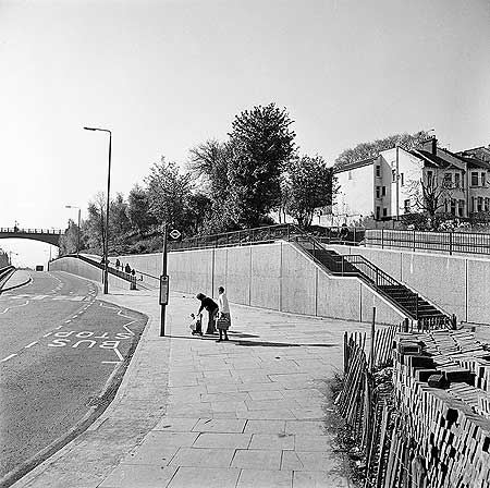 A couple get ready to head to Holloway in the 1960’s pictured just south of Archway Bridge (2 minutes east of ‘Archway Tower’ today), the light traffic is in contrast to the traffic today. I wonder where they’re heading?