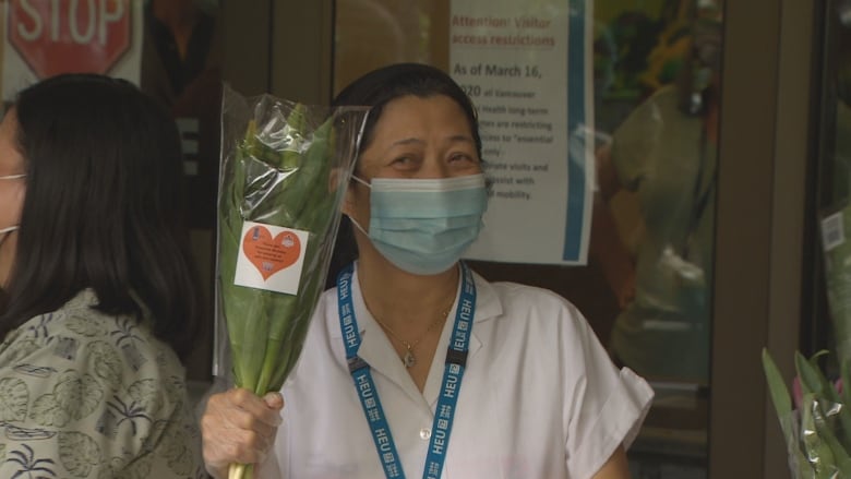 A frontline worker at the Haro Park Centre in Vancouver's West End receives a bouquet of tulips. (CBC) Frontline workers and seniors at care homes around the Lower Mainland received a welcome token of spring this week on behalf of the Dutch bit.ly/2zLzeXF