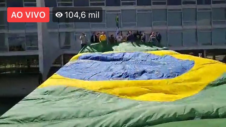 puttialexandre's tweet photo. Na manifestação de hoje, @jairbolsonaro estendeu uma bandeira do Brasil na rampa do Planalto. Segundo a lei N. 5.700, aprovada na ditadura, esse ato é considerado um desrespeito à Bandeira Nacional, e portanto proibido. Até para ser patriota ele comete um crime. https://t.co/U29LV12NfE