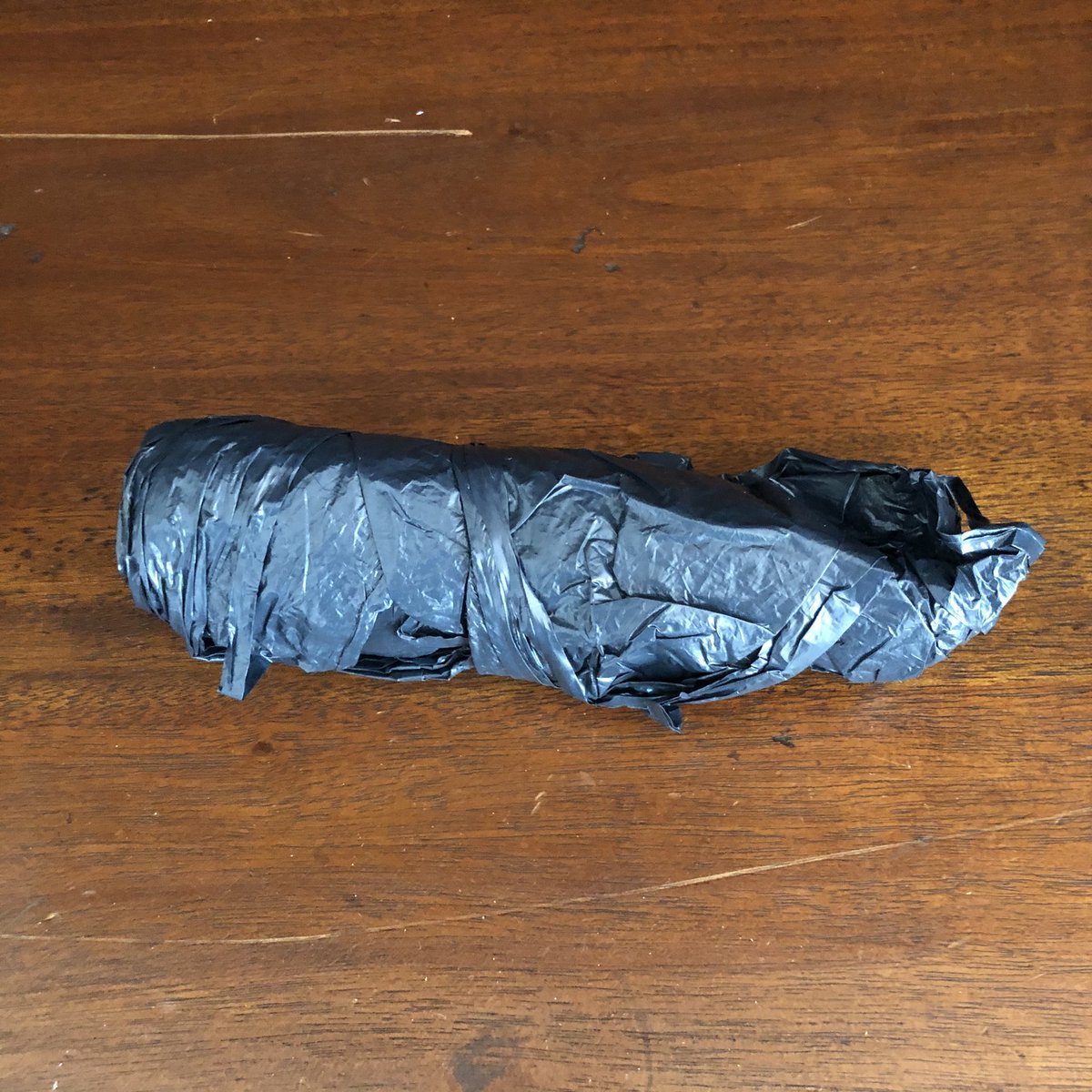 That solution involves two grocery bags, one for each side. These are the slightly heavier, black bags used at Virginia ABC stores for liquor purchases. They are rolled up as they live normally inside the rolled-up rain cover.