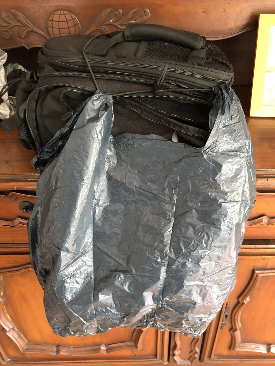 The top of the bag has an elastic cord with an adjustable cord stop. It would hold down a newspaper or pair of flip-flops stuffed into the top mesh pocket.