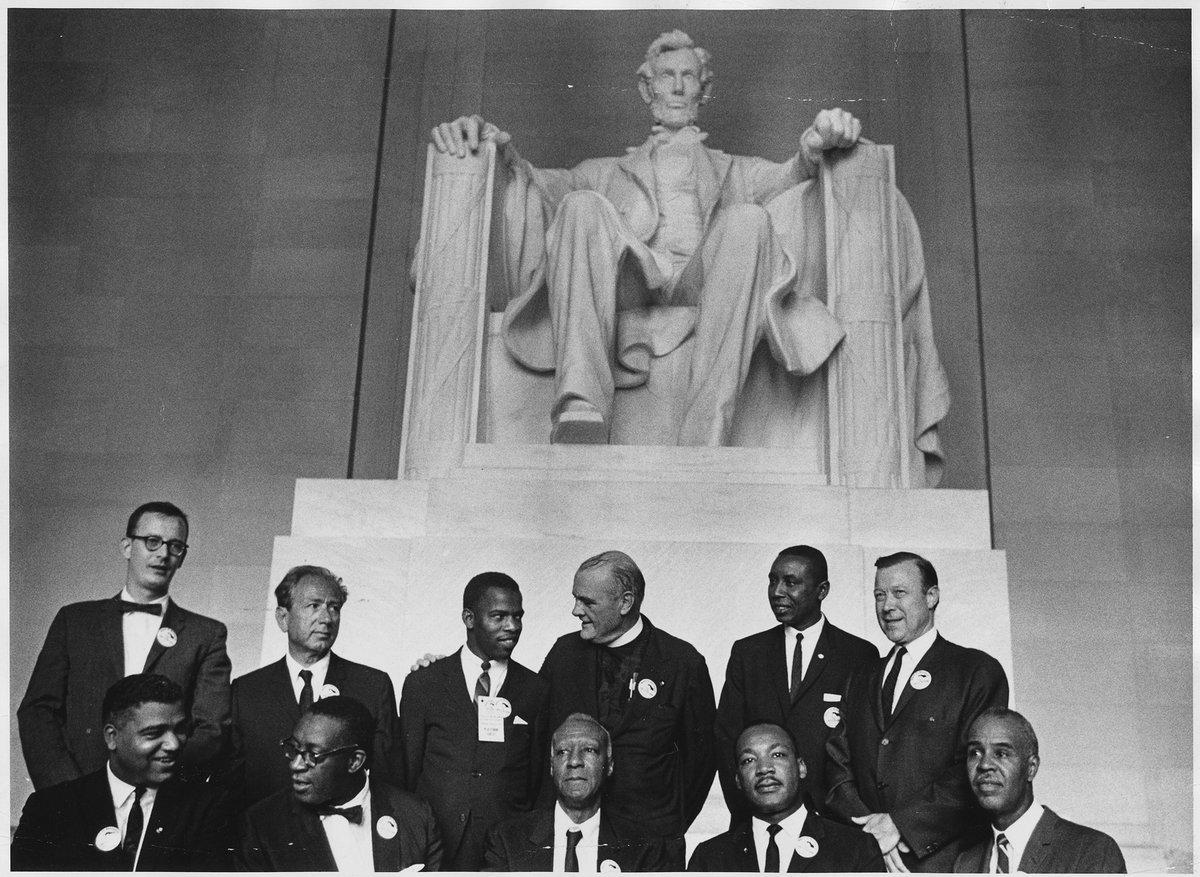 Pictured are: Matthew Ahmann, Rabbi Joachim Prinz, John Lewis, Protestant minister Eugene Carson Blake, Floyd McKissick, Walter Reuther, Whitney Young, Cleveland Robinson, A. Philip Randolph, Dr. Martin Luther King Jr., Roy Wilkins. The photo is at the Lincoln Memorial and is from August 28, 1963 during the March on Washington for Jobs and Freedom.