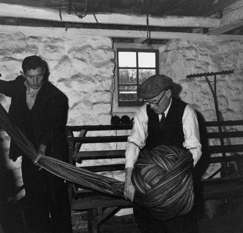 W E Morris and E J Evans warping at Esgair Moel Woollen Mill, April 1961. The mill was moved to the Museum in 1949, opened to the public in 1952, and Museum craftsmen continued with the work of processing the wool at the mill, from dyeing the fleece to finishing the fabric.
