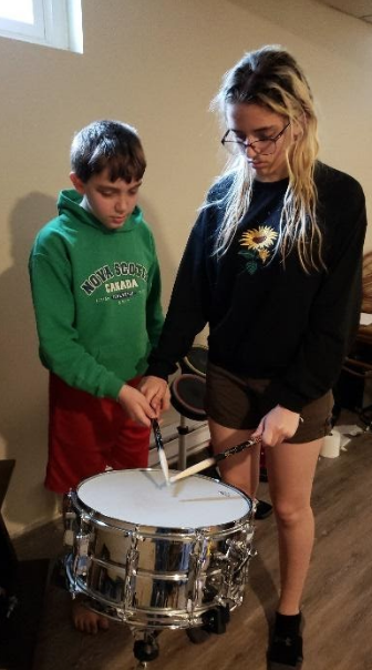 awassonmusic's tweet photo. Over next two weeks in band, students are completing the "50 Point Challenge." There are a variety of tasks that they can complete to add up to 50 points. Here is Ryan, a percussionist, teaching his sister how to properly hold drumsticks. Way to go Ryan! #musiced #ThisIsBMS https://t.co/XoFfxBUAtx