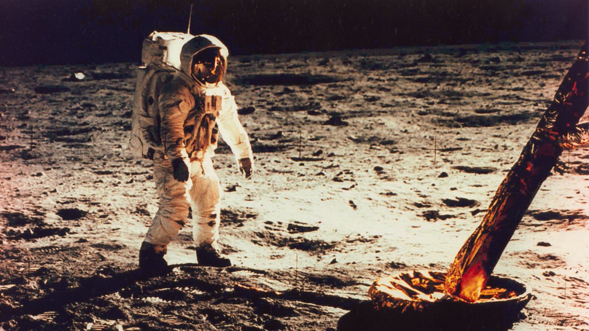 An astronaut walks on the surface of the moon.