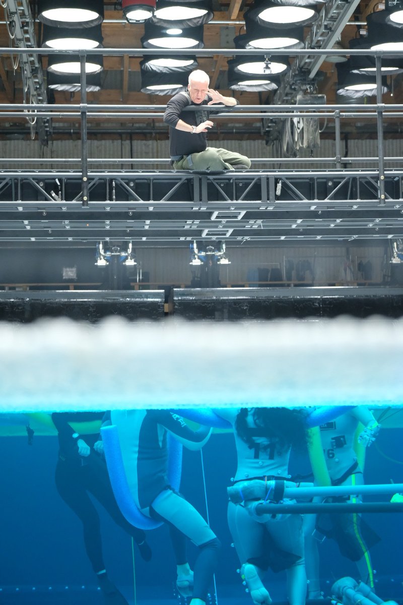 officialavatar's tweet photo. From the set of the sequels: @JimCameron directing the actors before they dive underwater for performance capture. 

Fun fact: That layer of white on the water's surface is comprised of floating balls that prevent lights from interfering with filming underwater. https://t.co/dOBwS6qOXF