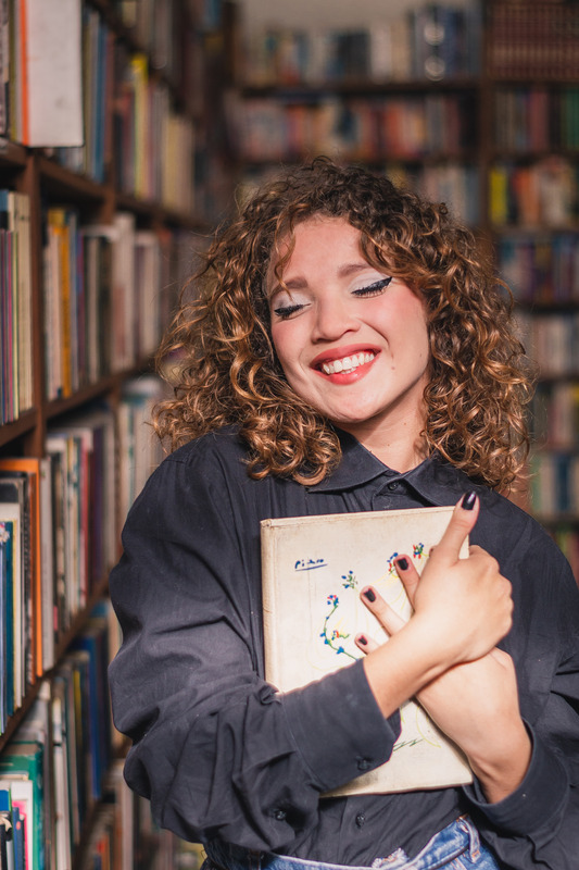 Woman holding book in library.
