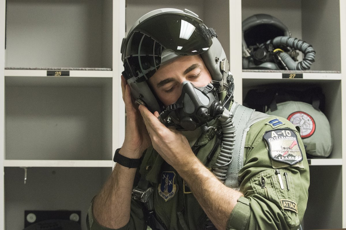 Idaho Air National Guard A-10 Thunderbolt II pilot Capt. Mike Shufeldt puts on his helmet in a room full of flying equipment, Feb. 13, 2020. Photo By: Air National Guard Master Sgt. Becky Vanshur)