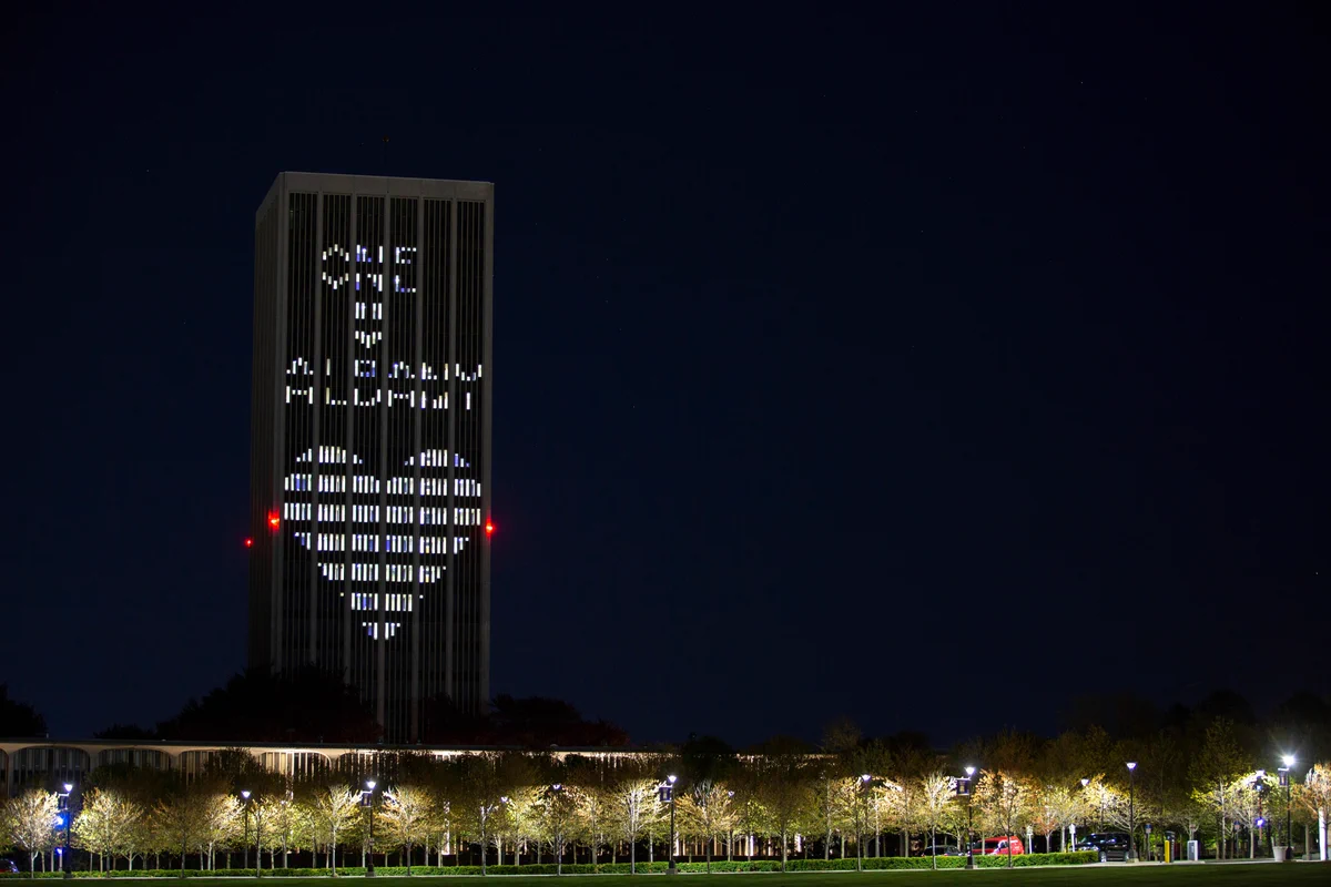 Eastman Tower on State Quad lit up with OneUAlbany and a heart.