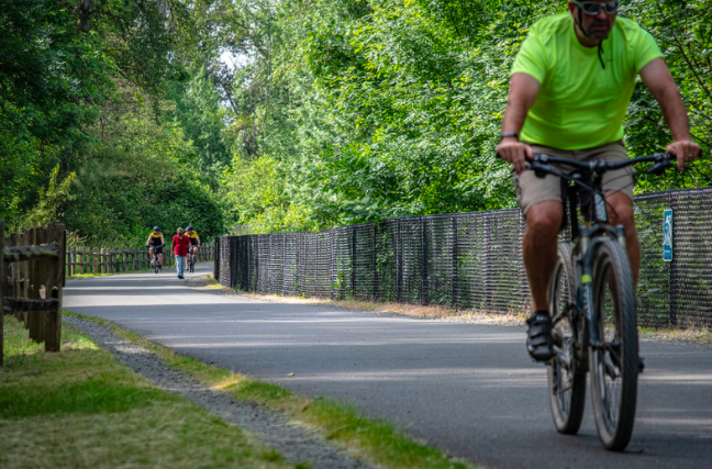 Image of a man cycling a safe distance away from a group of walkers