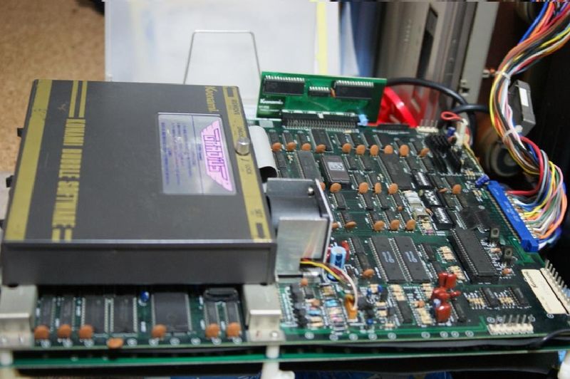 The idea was that you could have switchable game cartridges for the arcade system, in a format that's more resilient than floppies/hard drives but cheaper than ROM chips. The long startup time was due to the temperature requirements of the bubble memory.