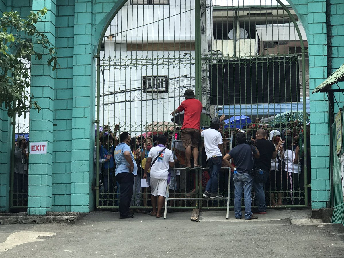LOOK: The gate of Barangay Pag-Asa Elementary School at high noon. Beneficiaries are still waiting at the gates |  @cnnphilippines