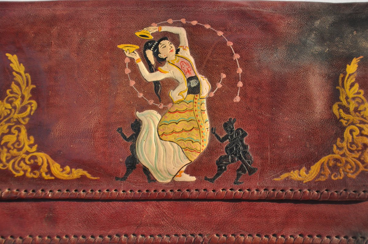 With traditional Burmese-style hand-painted figures: a dancing girl with cymbals accompanied by smaller figures playing goblet drums called ozi on the front, and on the back, a colourful rendition of musicians playing smaller finger-cymbals and a saung, the Burmese harp