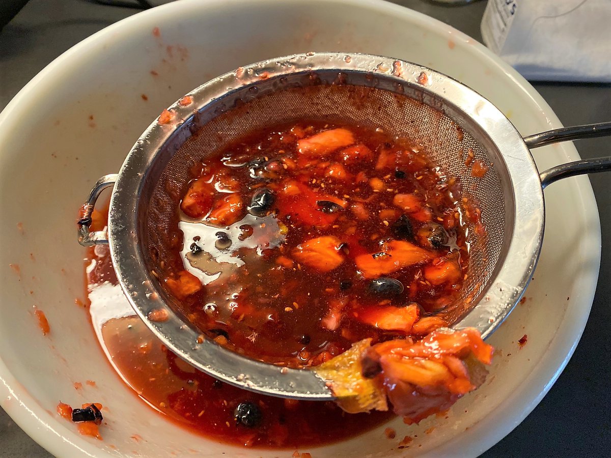 After a day or so, mash up the fruit, then strain it out, leaving the liquid behind. I use a series of successively fine metal strainers. Measure how much syrup you have, then place in a storage vessel such as a sterilized mason jar.