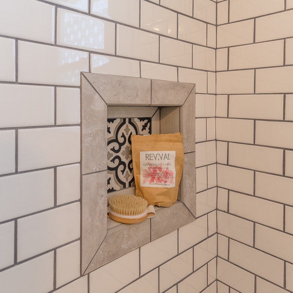 A custom tile inset with a single decorative tile creates a shelf for bath products. The decorative tile ties our color scheme together and is a nice focal point,

#smallspacesquad #subwaytile #bathroomdecor #cottagestyle #farmhousestyle #diy #ApartmentTherapy #decor #hometohave