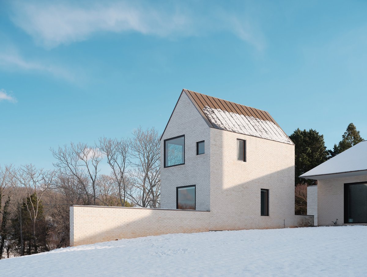 dezeen's tweet photo. The aptly named Chimney House features three slender, white chimneys that are 30-feet (nine-metres) high: https://t.co/HOEBrW3fxy https://t.co/ac0d0hVsIA