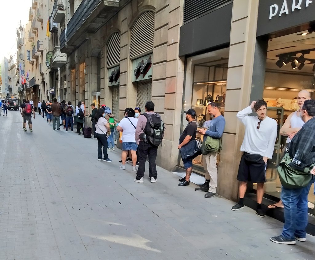 AdriaAlsina's tweet photo. La cua de gent esperant per rebre ajuda alimentària de l'Església de Santa Anna puja per Portal de l'Àngel i arriba fins a la Plaça Catalunya. Sense paraules. https://t.co/4yNgceU56m