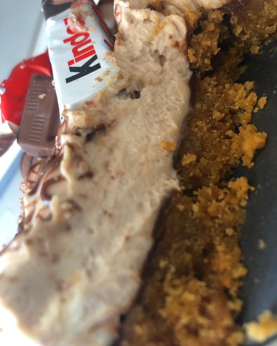 Kinder bueno cheesecake with a layer of hazelnut spread and drizzled chocolate on top and a kinder chocolate selection🤎🍫🤍