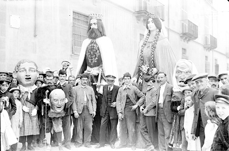 vic_cultura's tweet photo. 🗝️#pessicsdelarxiu En aquesta fotografia dels gegants de #Vic i la família cap de llúpia de principis de segle XX, s'hi pot veure el portador que va donar nom a "El Merma". Amb ell també va començar el tradicional crit de #MorielMerma! 

☝️ Sabeu com es deia? https://t.co/6Sq5caiEIL