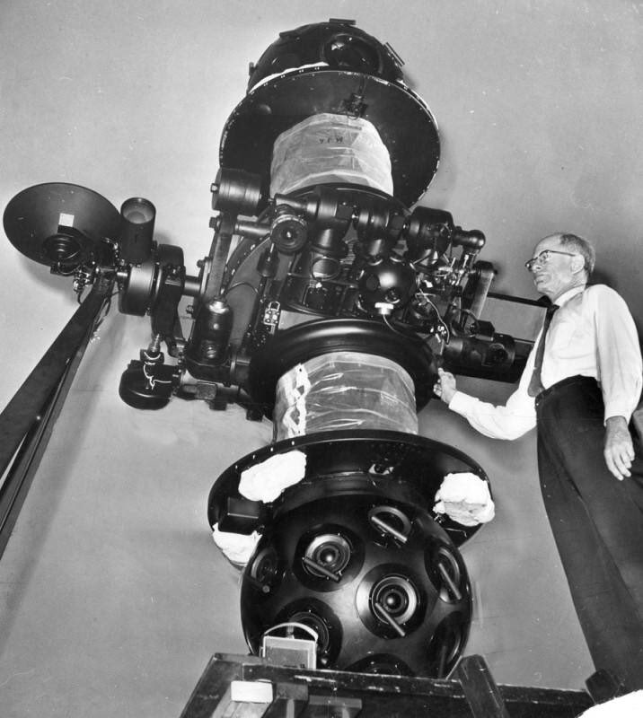 Man standing next to large projector