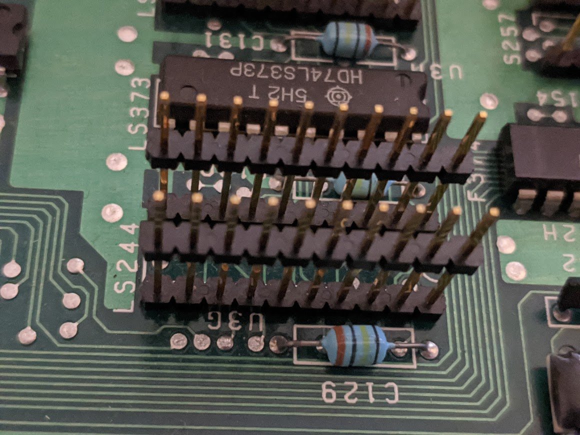 the daughterboard plugs into the motherboard using a whole bunch of pin headers, most of which are soldered into IC footprints! for example, the motherboard says this chip, U3G, is a 74LS244. what's the deal?