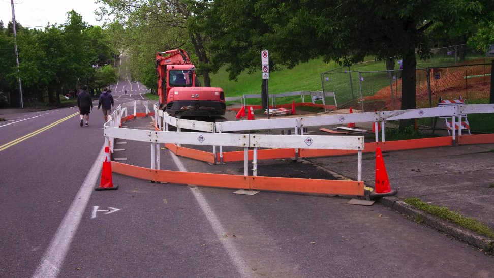 enobacon's tweet photo. Covid-19 physical distancing edition of the #WorkZoneWTF prize here on SW Vermont @BikePortland.  Why fence off the bike lane "bikes merge with autos" on this 20mph Local Service street?  People avoid the fenced area, autos don't "share" well when you leave them the yellow lines. https://t.co/fYHgnzTQIU