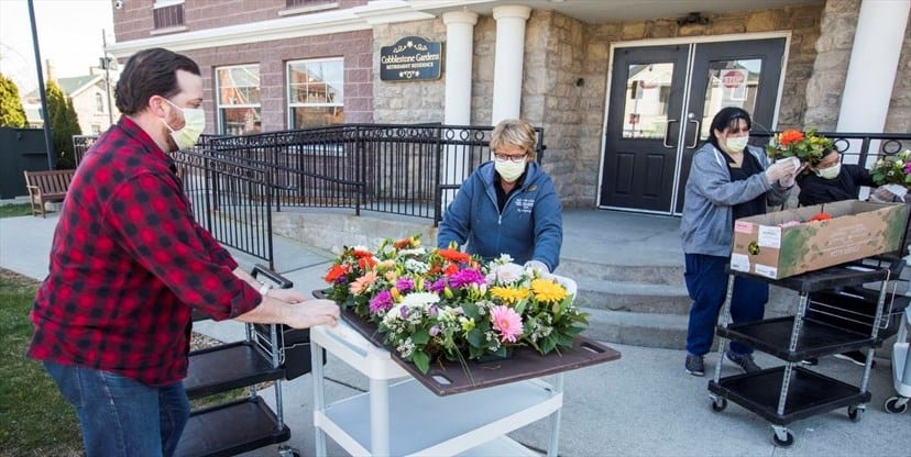 Michael and Lydia Rekrut drop off floral arrangements with Jeannie Redekop, right, at Cobblestone Gardens Retirement Residence in Thorold on Saturday morning. bit.ly/3dTpR73