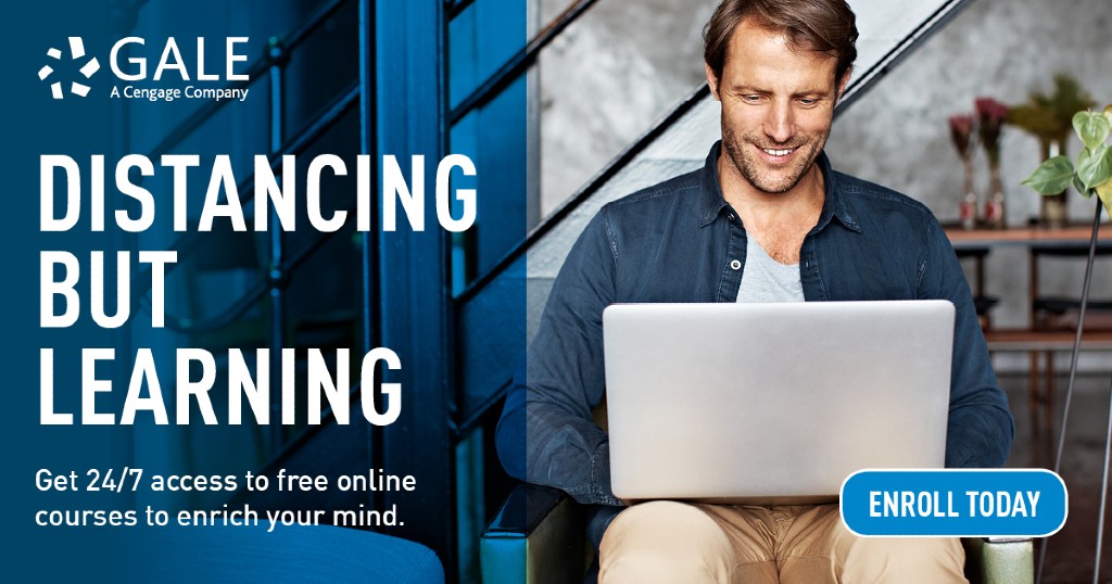 a man sitting on his couch with his computer on his lap, looking down at the screen smiling