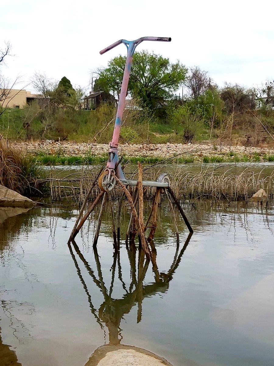 TimPughArtist's tweet photo. One of the trickiest balancing acts I've ever done, suspending this childs' scooter above the waters of the river Llano  Texas for the fabulous LEAF festival #Llano #texashillcountry #LEAF2020 https://t.co/SM1ADfrVH9