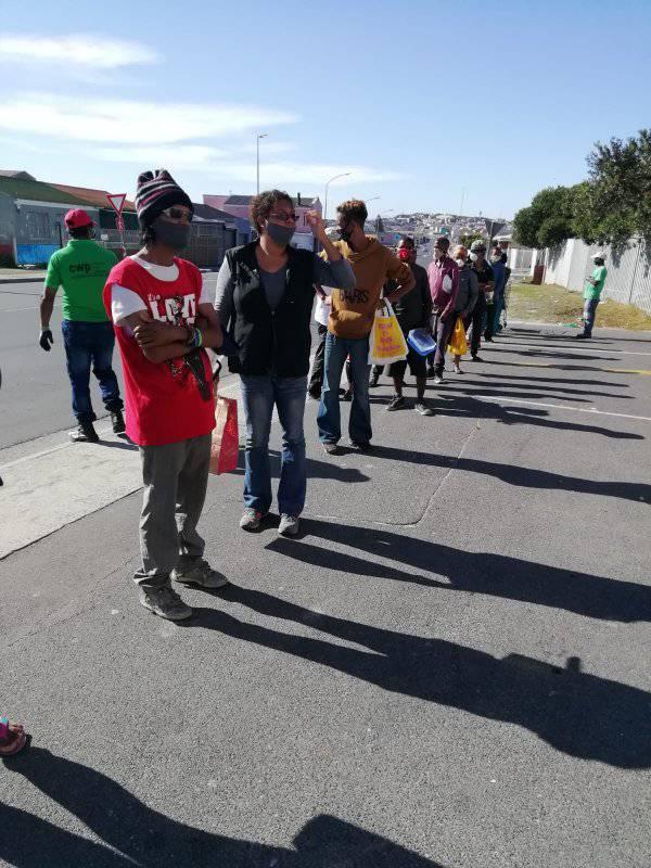 The face of Lockdown. People queuing outside a local church for a hot plate of food. The church provide two meals per week to the community of Tafelsig. Any support will be highly appreciated.