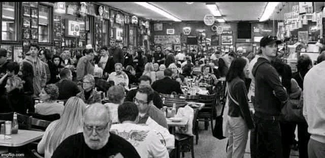 Am_wingman's tweet photo. An old photo of people eating in a restaurant
Photo was taken in 2019 B.C (before corona) https://t.co/ajh20dUUaj