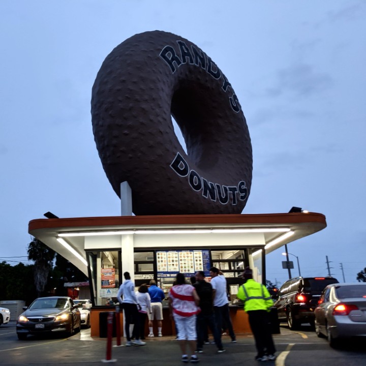 esotouric's tweet photo. One year ago, dusk gathers over the big donut, in a time when Angelenos stood closer together, and flocked to the cool weird places that defined us, and still do. #mydayinla #programmatic #giantthings #giantdonut https://t.co/EDe65gd5zg
