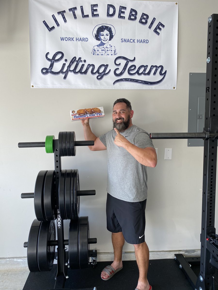CoachJustice's tweet photo. Was excited to get my little Debbie lifting team banner. It looks good in the garage gym and serves as a reminder set to #workhardsnackhard while I’m grinding out some lifts! Thank you for the personalized note @DanielMcKim https://t.co/pJk3hdptl4